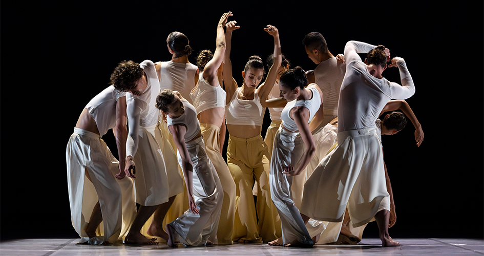Photo des artistes sur scène en groupe portant des costumes blancs